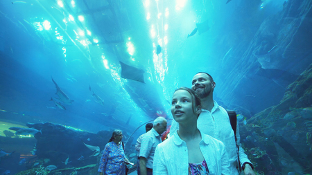 Dubai, UAE - April 09, 2018: Teenage girl with Dad admire the marine life in the glass tunnel of the Aquarium in Dubai Mallのeditorial素材