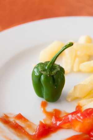 A green pepper in the dish with a red sauceの写真素材