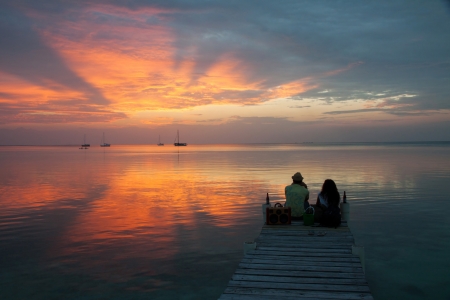A couple looking at the sunset in Caye Caulker, Belize の写真素材