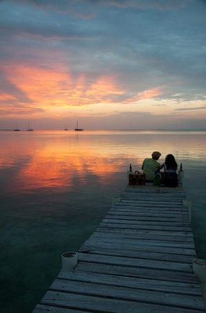 A couple looking at the sunset in Caye Caulker, Belize の写真素材