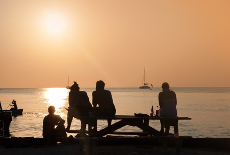 Young guys enjoying the sunset on the beachの写真素材