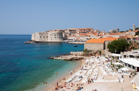 DUBROVNIK, CROATIA - JULY 21, 2013  Dubrownik old city castle and walls with tourists at the Banje beach のeditorial素材