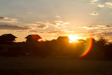 Sun dropping down the hill in a african villageの写真素材