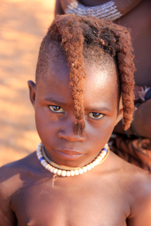 EPUPA, NAMIBIA- MAY 12, 2014: Unidentified child Himba tribe. Himba children show their traditional...