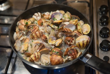 Cooking some clams with wine and parsley in the panの写真素材