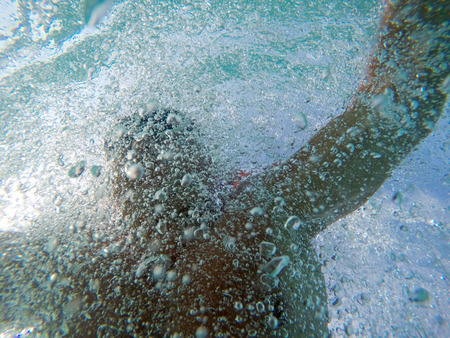 Swimming under water with a lot of bubblesの写真素材