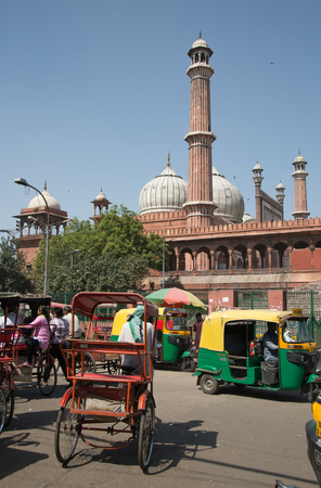OLD DELHI, INDIA - October 10, 2015: Overcrowded street in old town with smog, tuk tuk,  cycle rickshaws transports passenger and Jama masjid mosque in the backgroundのeditorial素材
