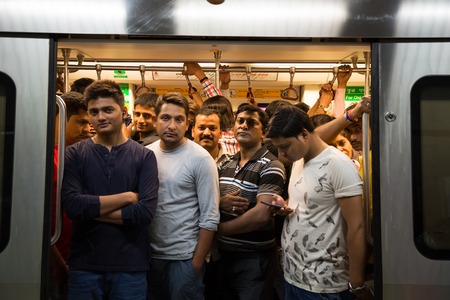 NEW DELHI, INDIA - OCTOBER 11, 2015: Crowd of people in the subway train in  in the  rush hour. They are waithing the door closing and the train departure.のeditorial素材