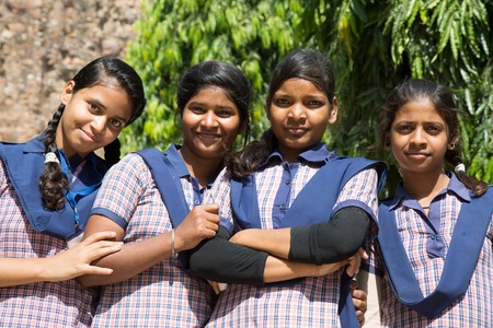 DELHI, INDIA - OCTOBER 11, 2015: unidentified local school girls for tour in Qutub Minar complex in Delhi, India. The girls  in school uniform have fun posing for a foto. Schools visit the famous landmarks as part of national education.のeditorial素材