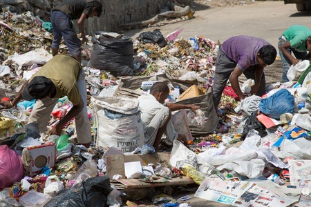NEW DELHI, INDIA - OCTOBER 11, 2015: Big garbage heap and unidentified people looking for something...