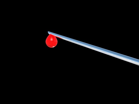 Needle of syringe with red blood drop. Isolated over black baclgroundの写真素材