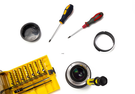 Camera lens repair flat lay view on white background. Beginning of disassembly.