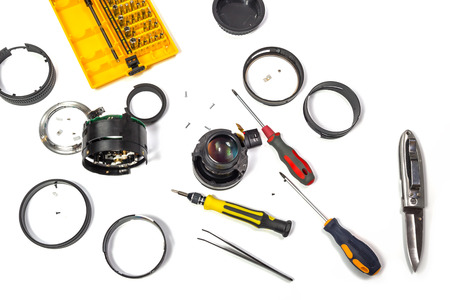 Camera lens repair flat lay view on white background. Lens is half-disassembled.の写真素材