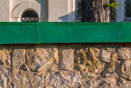 limestone fence with green metal top background with selective focusの写真素材