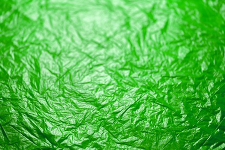 crumpled ufo green polyethilene film abstract background with selective focus
