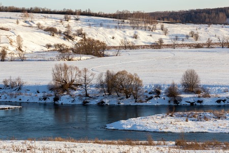 winter russian riverside wiew under direct evening sunlightの写真素材
