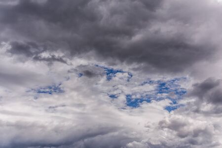 gray incoming near storm clouds at daylight backdropの写真素材