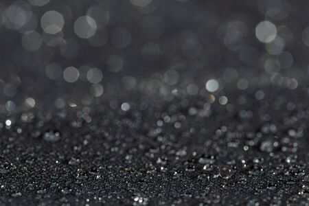 dark gray waterproof hydrophobic flat cloth closeup with rain drops selective focus background