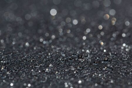 dark gray waterproof hydrophobic flat cloth closeup with rain drops selective focus backgroundの写真素材
