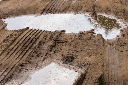 puddles in roadside dirt telephoto closeup shot with selective focus and blur