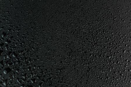 Water drops on flat black rubber surface macro backgroundの写真素材