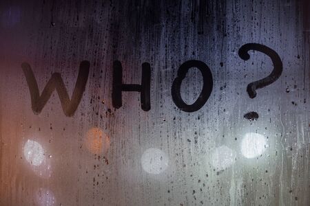the question who written by finger on night wet glass with blurred lights in backgroundの写真素材