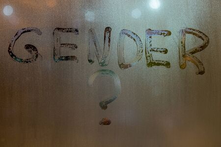 the question gender written by finger on night wet glass with blurred lights in backgroundの写真素材