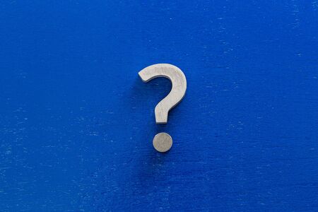 A question sign on center of blue painted board - flat lay coneptの写真素材