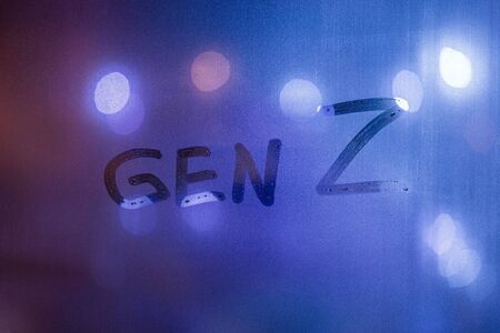 The words gen z handwritten on night wet window glass with blurry phantom blue lights in backgroundの写真素材