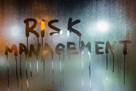 the word risk management handwritten on night wet window glassの写真素材