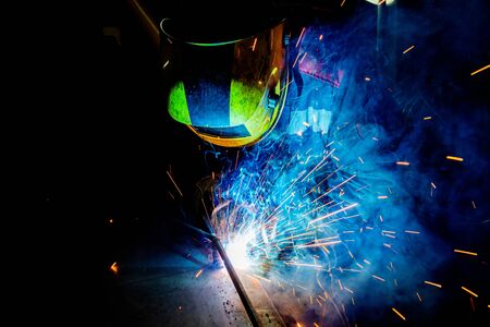 A process of manual operational semi-automatic electric MIG welding with sparks, ndustrial worker in...