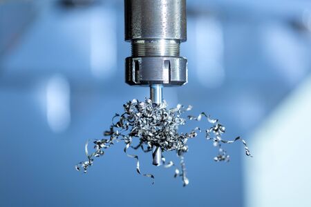 A close-up view on collet chuck and swarf wrapped over carbide drill. Feed and cutting speed...