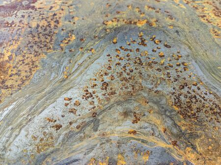 Rusted metal sheet close-up background with selective focus and blur. Wave-like rust pattern.
