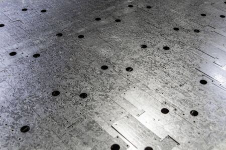 zync plated metal sheet ofter cnc laser cutting - close-up with selective focus and diagonal composition.の写真素材