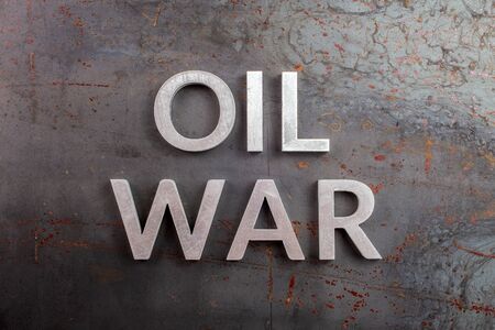 words oil war laid with silver metal letters on rusted heavy hot rolled uncoated steel sheet surface - directly aboveの写真素材