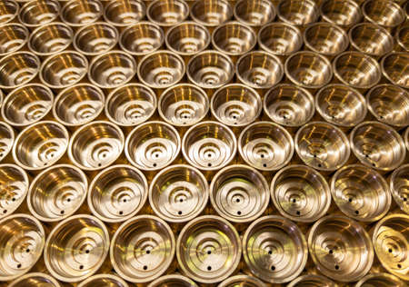 an abstract perspective industrial close-up background of shiny brass metal threaded hexagonal fitting partsの写真素材