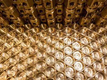 an abstract industrial close-up background of shiny brass metal threaded hexagonal fitting partsの写真素材