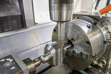 unadorned photo of automated milling metal part on cnc machineの写真素材