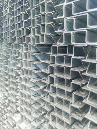 Full frame stack of bended zinc plated sheet metal parts - close-up with selective focus and blur. Sheet bending parts backdrop.の写真素材