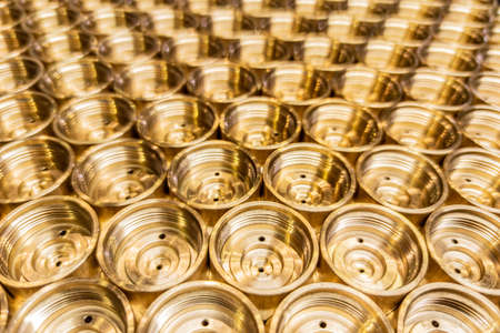 an abstract perspective industrial close-up background of shiny brass metal threaded hexagonal fitting partsの写真素材