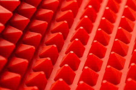abstract red silicone pyramids mat close-up backgroundの写真素材