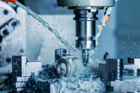 vertical cnc steel milling process with external water coolant streams, splashes and a lot of metal...