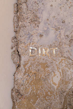 the word mud imprinted in wet dirt road surface - close-up with selective focusの写真素材
