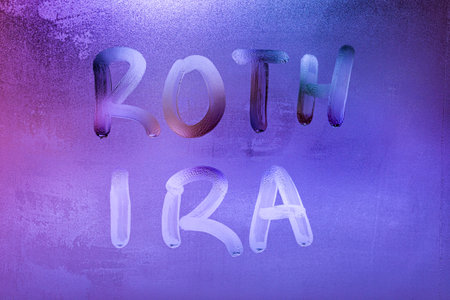 the words roth ira handwritten on night wet window glass surfaceの写真素材