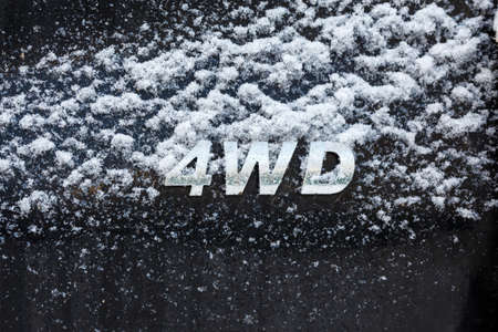 an abbreviation 4wd - Four-wheel drive - on dirty black car backの写真素材