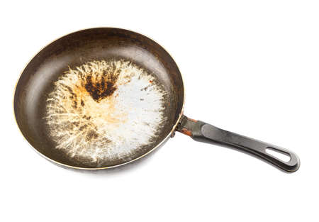 old stained aluminium pan with burnt fat and peeled off TFE non-stick coating and burnt fat isolatedの写真素材