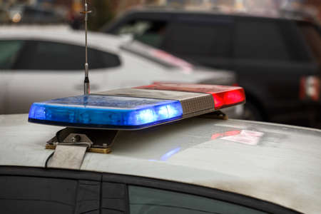police car lights in city street at winter day with cars traffic in blurry backgroundの写真素材