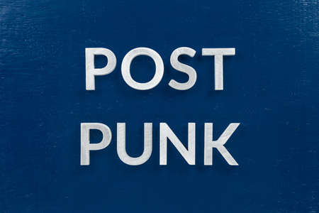 Words Post Punk laid with aluminum letters on blue painted board surface