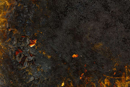 Bottom side of a cast iron pan with thicl layer of soot on it.