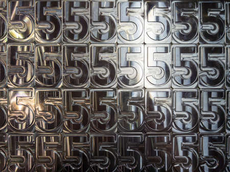 shiny metal machined digit 5 plates tiled tightly - close-up full frame backgroundの写真素材